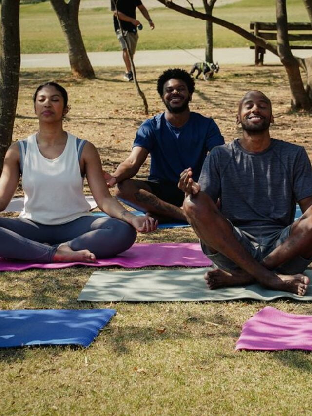 Fot de um grupo de pessoas fazendo yoga e meditação ao ar livre.